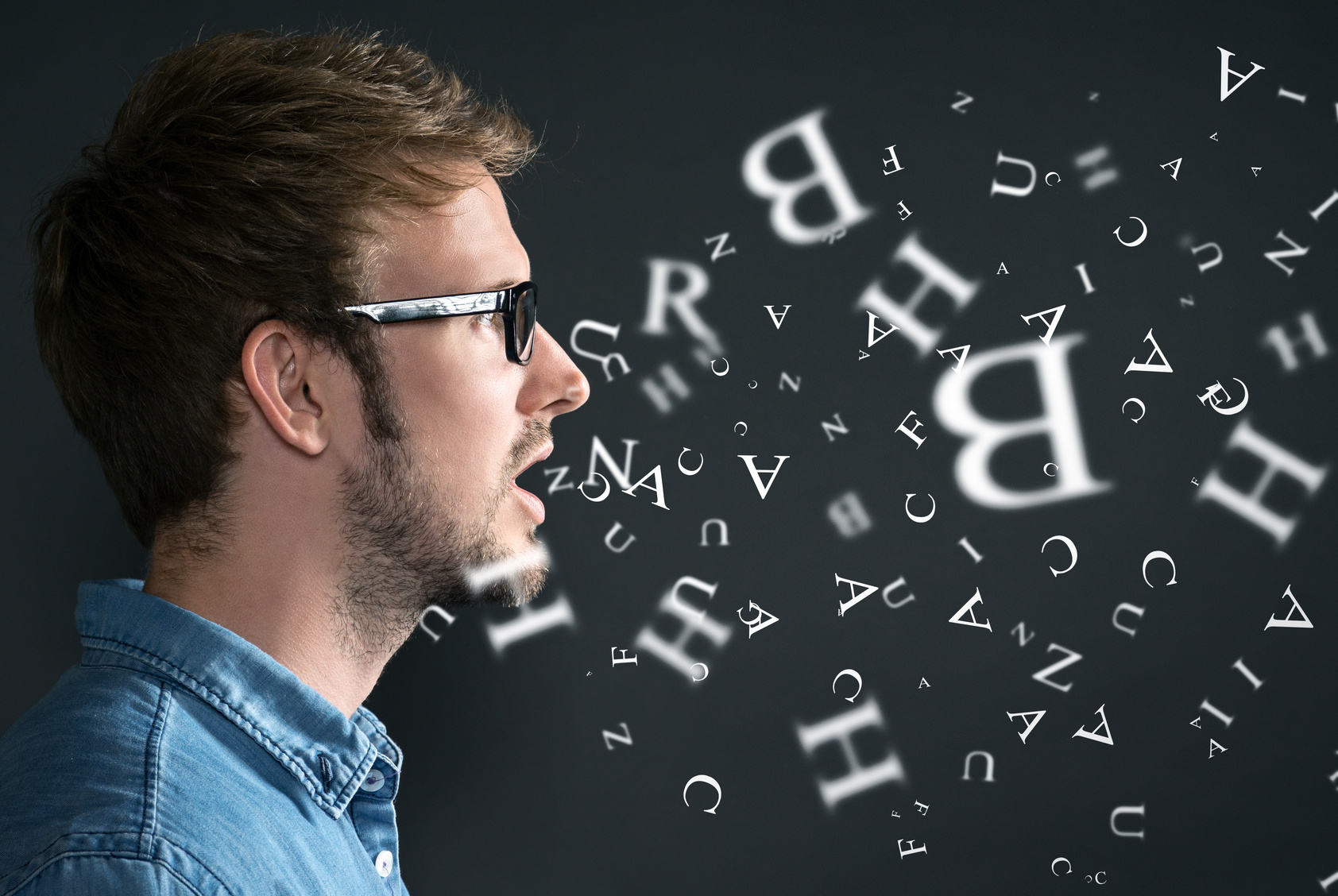 Ein mann im Profil, dem einzelne Buchstaben aus dem Mund fliegen